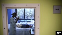 FILE - A nurse speaks with a patient with mental disorders in her room at The Ville-Evrard Psychiatric Hospital in Saint-Denis, north of Paris, France, Nov. 3, 2020, as more cases of mental illness are being linked to COVID-19.