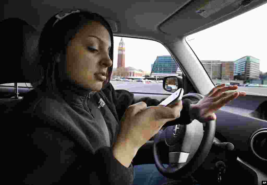 New driver Brandi Eadie, 16, looks down at her cell phone to read a text message as she drives through a rubber-cone course in Seattle on Wednesday, Jan. 6, 2010 to demonstrate the dangers of phone use while driving. Eadie, who volunteered for the Driven