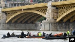Rescuers in boats work to prepare to recover a capsized boat under Margaret Bridge in Budapest, Hungary, May 30, 2019. 