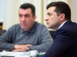 FILE - Ukrainian President Volodymyr Zelenskiy, right, leads a meeting of the emergency response team on the crash of the Ukraine International Airlines plane in Iran, in Kyiv, Ukraine, Jan. 9, 2020.