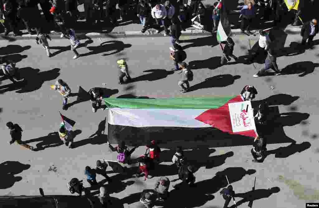 People carry a large Palestinian flag during a rally Hebron, occupied West Bank, November 29, 2012.