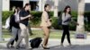 Students walk past a "Vote" sign next to an early voting site on the Florida International University campus, Oct. 23, 2018, in Miami. 