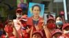 Myanmar migrants hold up portraits of detained leader Aung San Suu Kyi as they rally outside Myanmar's embassy in Bangkok, Thailand, Feb. 1, 2021.