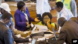 Official representatives of the various political parties and electoral workers discuss while reviewing newly received results, at the National Tallying Center in Nairobi, Kenya, Mar. 6, 2013.