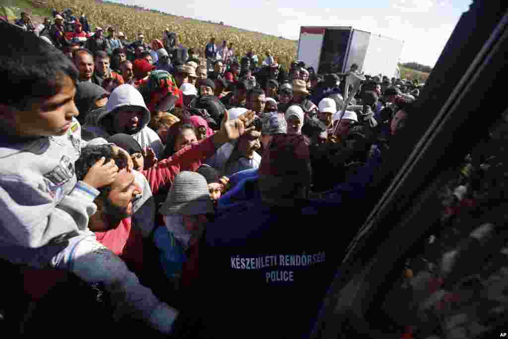 Migrants in Roszke board a bus.