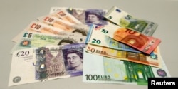 FILE - British pounds and Euro banknotes are pictured in a bank at the main train station in Munich, Germany, June 24, 2016 after Britain voted to leave the European Union.