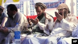 FILE - The alleged mastermind of the 2008 Mumbai attacks, Pakistani Zaki-ur-Rehman Lakhvi, center, is seen praying with others on June 28, 2008, in Muzaffarabad, capital of Pakistani Kashmir.
