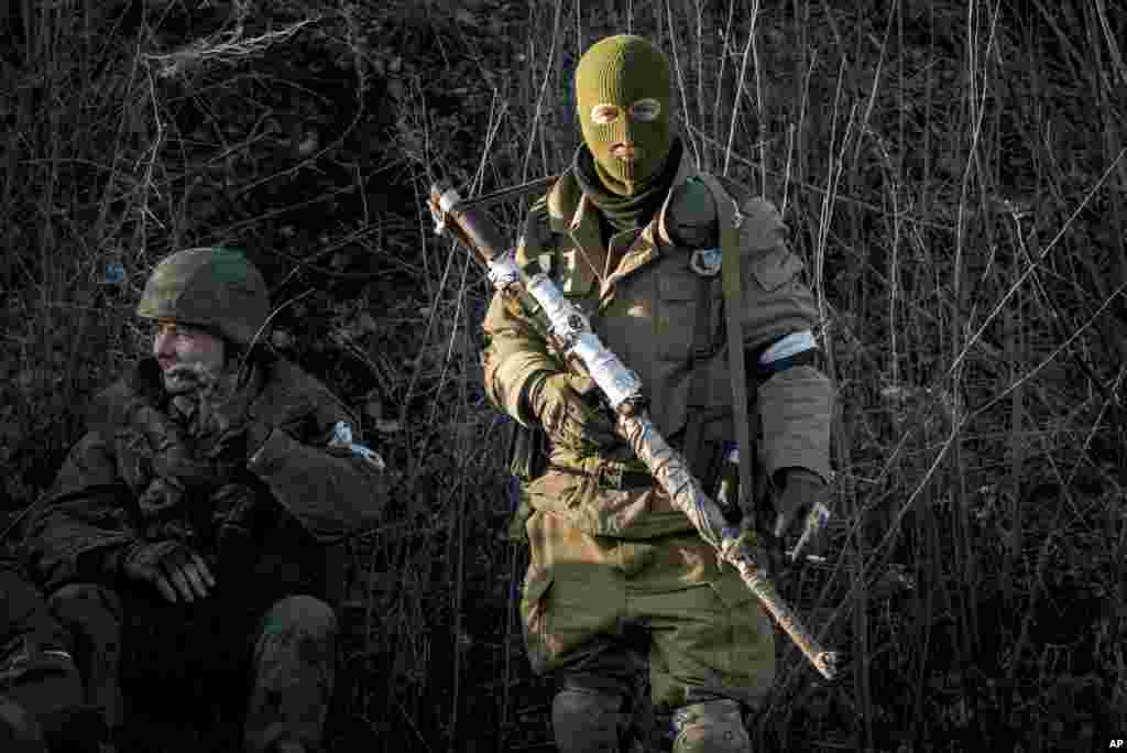 Russian-backed separatists wait for their transport, preparing to leave for the frontline, in the village of Vergulivka, just outside Debaltseve, eastern Ukraine, Feb. 13, 2015.