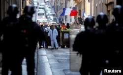 Police officers are seen in front of protesters wearing yellow vests during a demonstration in Marseille, France, Jan. 19, 2019.