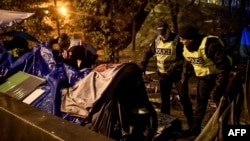 Polisi bicara dengan tunawisma di tendanya di Paris, Perancis (foto: ilustrasi). 