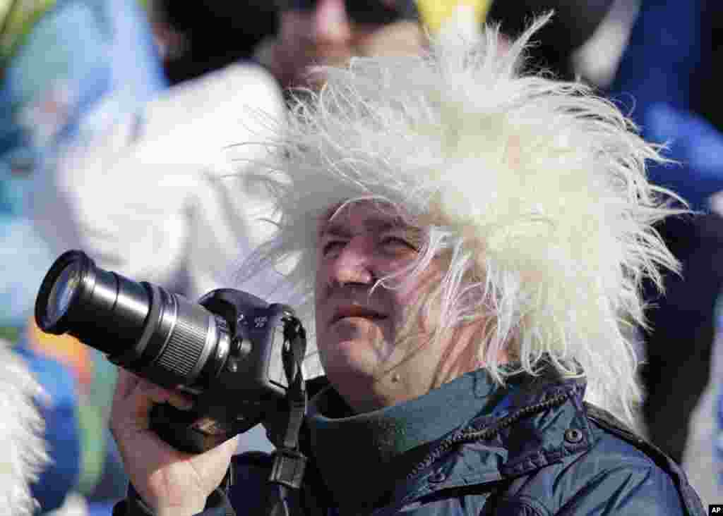 A spectator wears a fuzzy hat as he watches athletes compete in the downhill portion of the women's supercombined, Krasnaya Polyana, Russia, Feb. 10, 2014.