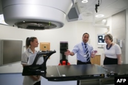 British Prime Minister Theresa May, right, is shown the advanced radiotherapy system during a visit to announce new funding and research into prostate cancer, at Addenbrooke's Hospital in Cambridge, England on April 10, 2018.