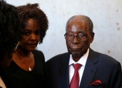 FILE - Zimbabwe's former President Robert Mugabe and his wife, Grace, vote in the general elections in Harare, Zimbabwe, July 30, 2018.