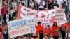 FILE - People hold placards and banners during a demonstration called by far-right and COVID-19 deniers to protest restrictions related to the coronavirus pandemic, in Berlin, Aug. 29, 2020.