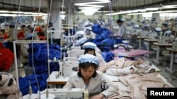 FILE - Karyawan Korea Utara, menjahit di perusahaan milik Korea Selatan di kawasan industri Kaesong di utara zona demiliterisasi, Desember 2013.