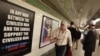 Cyrus McGoldrick, a member of the Council on American-Islamic Relations, talks to commuters as they walk by an advertisement that reads "Support Israel/Defeat Jihad" in the Times Square subway station in New York, September 24, 2012.