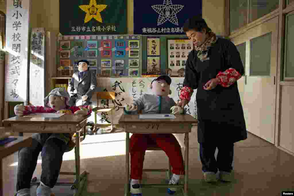 Tsukimi Ayano stands in a classroom with scarecrows at a closed down school in the village of Nagoro on Shikoku Island. The tiny village in southern Japan is teeming with Ayano's hand-sewn creations, frozen in time for a tableau that captures the motions of everyday life.
