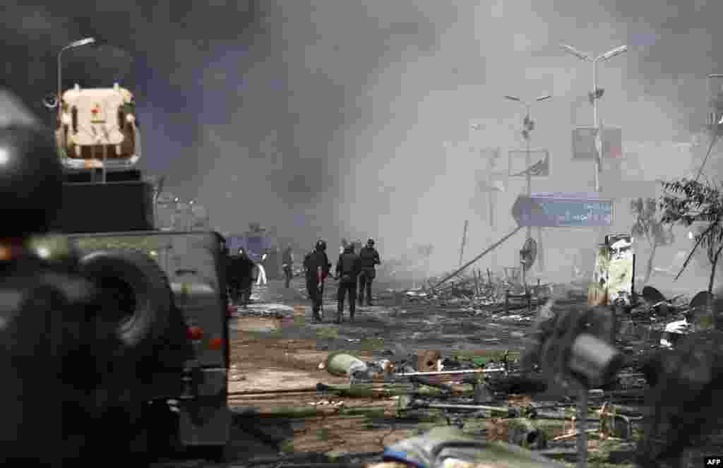 Egyptian security forces stand amidst remains of a protest camp by supporters of ousted president Mohamed Morsi after a crackdown near Cairo&#39;s Rabaa al-Adawiya mosque, Aug. 14, 2013.