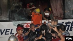 Petugas medis mengangkat seorang penumpang yang selamat dari pembajakan bis di Manila, 23 Agustus 2010.