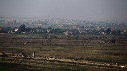 FILE - This photo taken Nov. 12, 2018, from Al Qaim in Iraq's border Anbar province shows the Syrian border city of Albukamal.