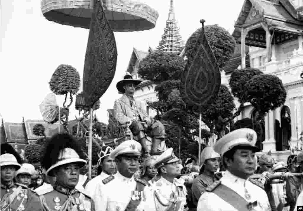ព្រះមហាក្សត្រថៃព្រះបាទ Bhumidol Adulyadej គង់នៅលើគ្រែស្នែងអំឡុងពេលក្បួនដង្ហែមួយក្នុងក្រុងបាងកក កាលពីថ្ងៃទី០៧ ខែធ្នូ ឆ្នាំ១៩៦៣។ ក្បួនដង្ហែនេះធ្វើឡើងដើម្បីអបអរសាទរពិធីបុណ្យចម្រើនព្រះជន្ម ៣៦ ព្រះវស្សារបស់ព្រះអង្គ ដែលមានរយៈពេលមួយសប្តាហ៍។