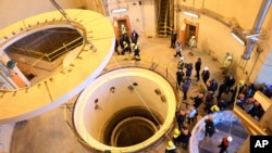 FILE - In this photo released by the Atomic Energy Organization of Iran, technicians work at the Arak heavy water reactor's secondary circuit, as officials and media visit the site, near Arak, Iran, Dec. 23, 2019. 