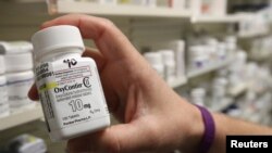 FILE - A pharmacist holds a bottle of OxyContin made by Purdue Pharma, at a pharmacy in Provo, Utah, May 9, 2019.