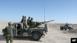 Para prajurit dari Tentara Nasional Afghanistan berjaga di pos pemeriksaan menuju distrik Sangin di Provinsi Helmand, Afghanistan, 23 Desember 2015.