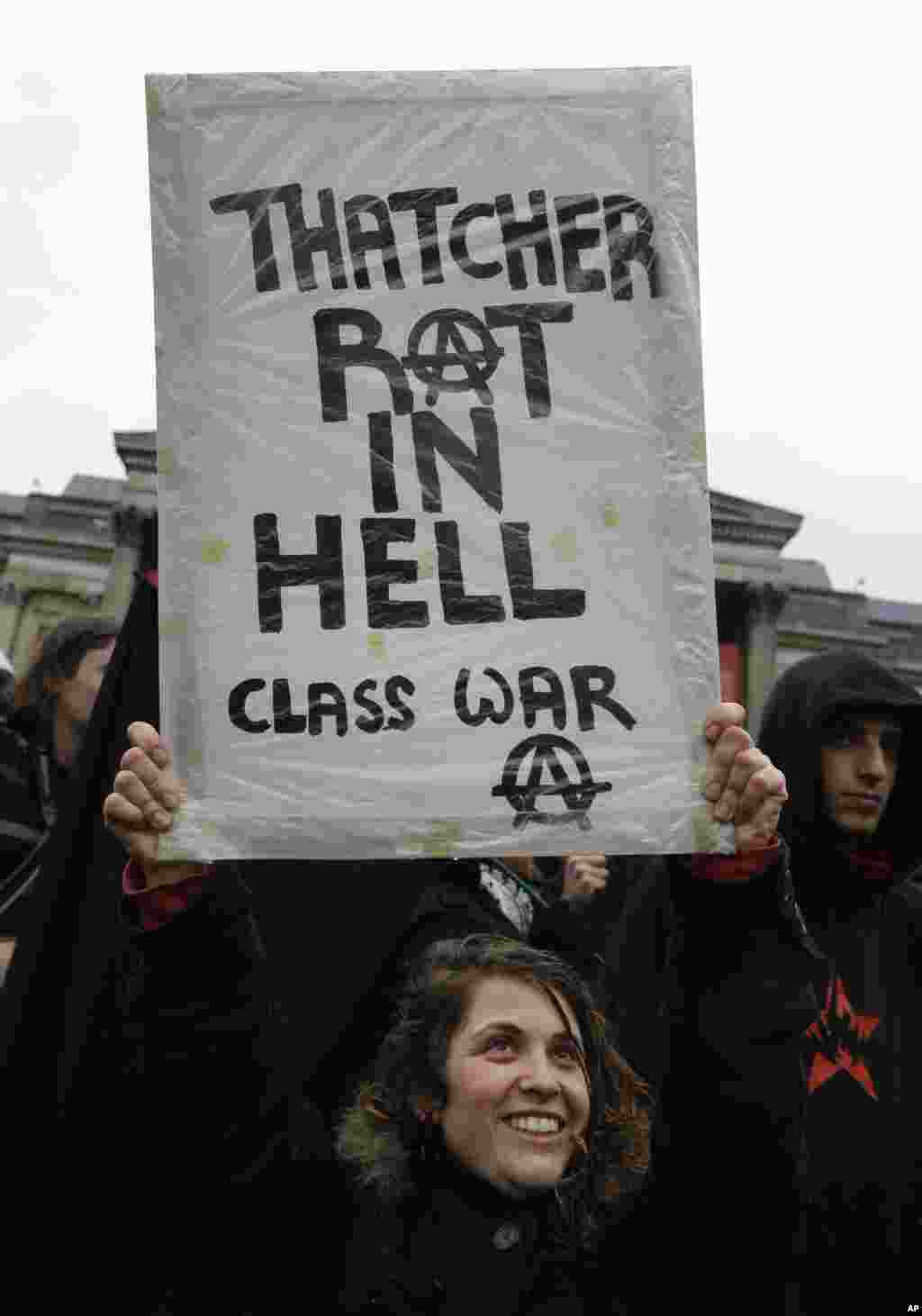 A protester holds a placard during a party to mark former British Prime Minister Margaret Thatcher's death in central London's Trafalgar square, April 13, 2013. 