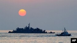 A South Korean goverment ship (R) sails by Navy MSB (Movement Sea Base) off the South Korea-controlled island of Yeonpyeong near the disputed waters of the Yellow Sea, 22 Dec 2010