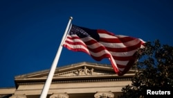 Bendera Amerika berkibar di luar Gedung Departemen Kehakiman AS di Washington, AS, 15 Desember 2020. (REUTERS/Al Drago Department of Justice)