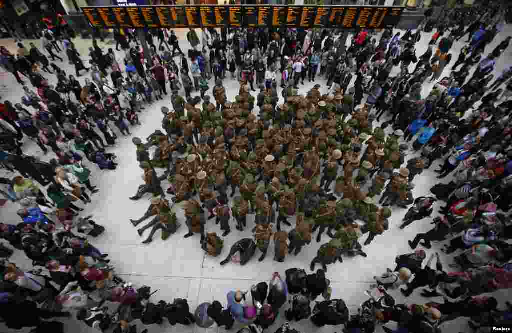 Actors dressed in World War 1 army fatigues gather in a group at Waterloo Station, to commemorate the start of the Battle of The Somme, in London, Britain.