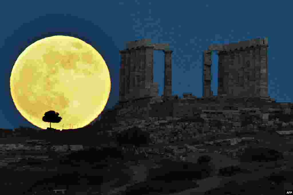 Bulan purnama "super" tampak di belakang kuil Yunani kuno Poseidon di Cape Sounion, sekitar 65 kilometer sebelah selatan Athena, Yunani.