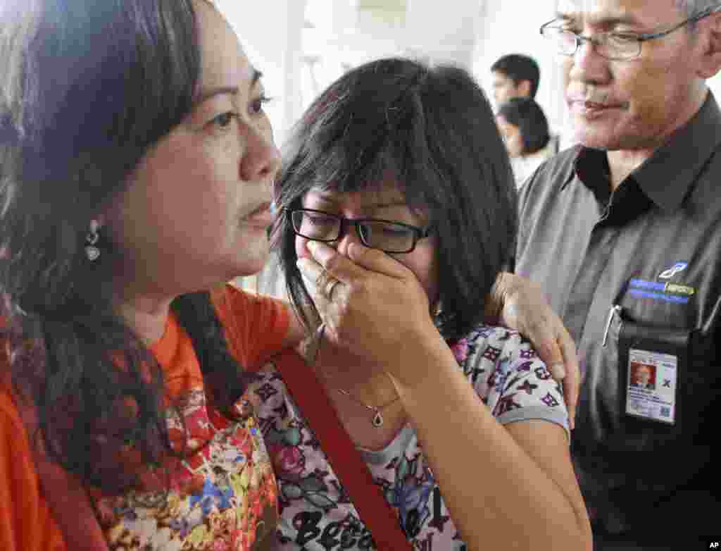 Seorang keluarga penumpang AirAsia QZ8501 menitikkan air mata selagi menunggu berita terbaru tentang pesawat yang hilang tersebut di Bandara Internasional Juanda di Surabaya, Jawa Timur, Indonesia, 28 Desember 2014.