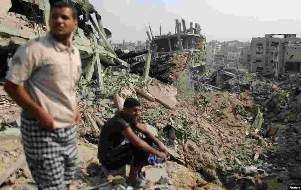 Palestinians look at destroyed houses after returning to the Shejaia neighborhood, which witnesses said was heavily hit by Israeli shelling and air strikes during the Israeli offensive, east of Gaza City, Aug. 5, 2014. 