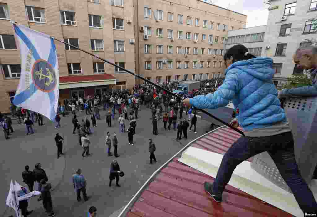 Pro-Russian supporters gather outside the regional government headquarters in Luhansk, eastern Ukraine, April 29, 2014. Hundreds of pro-Russian separatists stormed the headquarters on Tuesday, taking over the building.