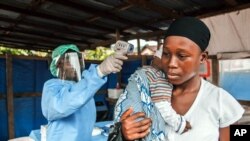 Contrôle de température avant d'entrer à l'hôpital public Macauley de Freetown, en Sierra Leone, le 21 janvier 2016. 