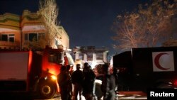 Afghan policemen stand at the site of a Taliban attack on a foreign aid workers' guest house in Kabul Nov. 29, 2014.