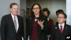 Komisioner Eropa untuk Perdagangan Cecilia Malmstrom, Menteri Ekonomi, Perdagangan dan Industri Jepang Hiroshige Seko, kanan, dan Perwakilan Perdagangan AS Robert Lighthizer dalam foto sebelum pertemuan di markas besar EU di Brussels, 10 Maret 2018.