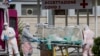 A patient in a biocontainment unit is carried on a stretcher from an ambulance arrived at the Columbus Covid 2 Hospital in Rome, March 17, 2020.