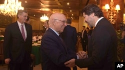 Wakil menteri luar negeri Afghanistan, Hekmat Khalil Karzai, kanan, dan penasehat urusan luar negeri Pakistan Sartaj Aziz bersalaman sebelum perundingan empat negara untuk mengembangkan proses perdamaian bagi Afghanistan.