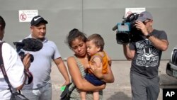 File- Adalicia Montecino and her husband Rolando Bueso Castillo walk with their year-old son Johan Bueso Montecinos, who became a poster child for the U.S. policy of separating immigrants and their children, in San Pedro, Feb. 4, 2017.