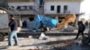 Residents inspect the damage as blood stains are seen on the ground after airstrikes by pro-Syrian government forces in the rebel-held al-Sakhour neighborhood of Aleppo, Syria, Feb. 8, 2016. 