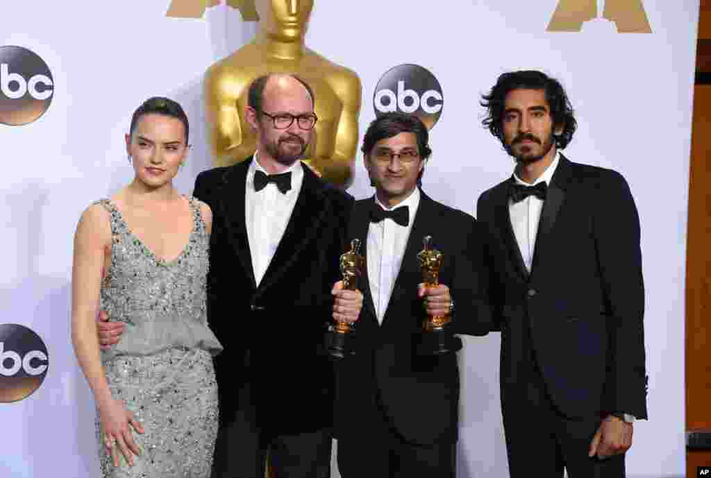 Daisy Ridley, left, and Dev Patel, right, pose in the press room with James Gay-Rees, left, and Asif Kapadia, winners of the award for best documentary feature for “Amy”, at the Oscars on Feb. 28, 2016, at the Dolby Theatre in Los Angeles.