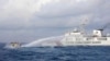 In this handout photo provided by the Philippine Coast Guard, a Chinese Coast Guard ship uses water cannons on Philippine navy-operated supply boat M/L Kalayaan as it approaches Second Thomas Shoal in the disputed South China Sea on Dec. 10, 2023. (Philippine Coast Guard via AP)