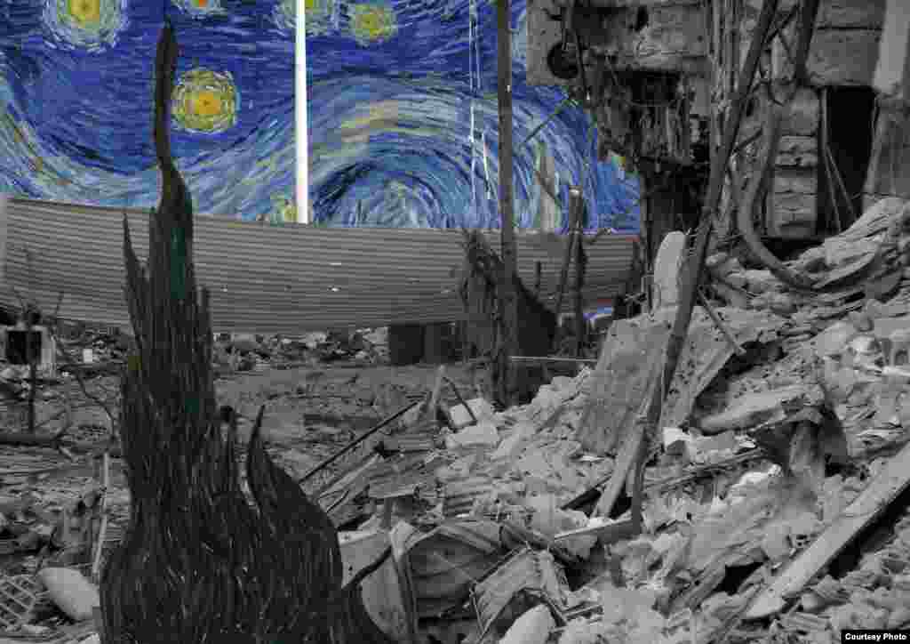 "Starry Night" karya Vincent Van Gogh menyelinap di belakang tumpukan kaleng, baja dan beton di sebuah daerah di Daraya.