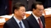 FILE - Chinese President Xi Jinping, left, stands as Premier Li Keqiang arrives for the closing session of China's National People's Congress at the Great Hall of the People in Beijing, March 15, 2019.
