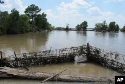 FILE - In this Aug. 31, 2017 photo, a barbed-wire fence encircles the Highlands Acid Pit that was flooded by water from the nearby San Jacinto River as a result from Harvey in Highlands, Texas.