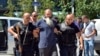 FILE - Kosovo police escort a man suspected of having fought with Islamist insurgents in Syria and Iraq, in Pristina, Aug. 12, 2014. Kosovo has taken a proactive approach to reintegrating citizens who joined the IS.