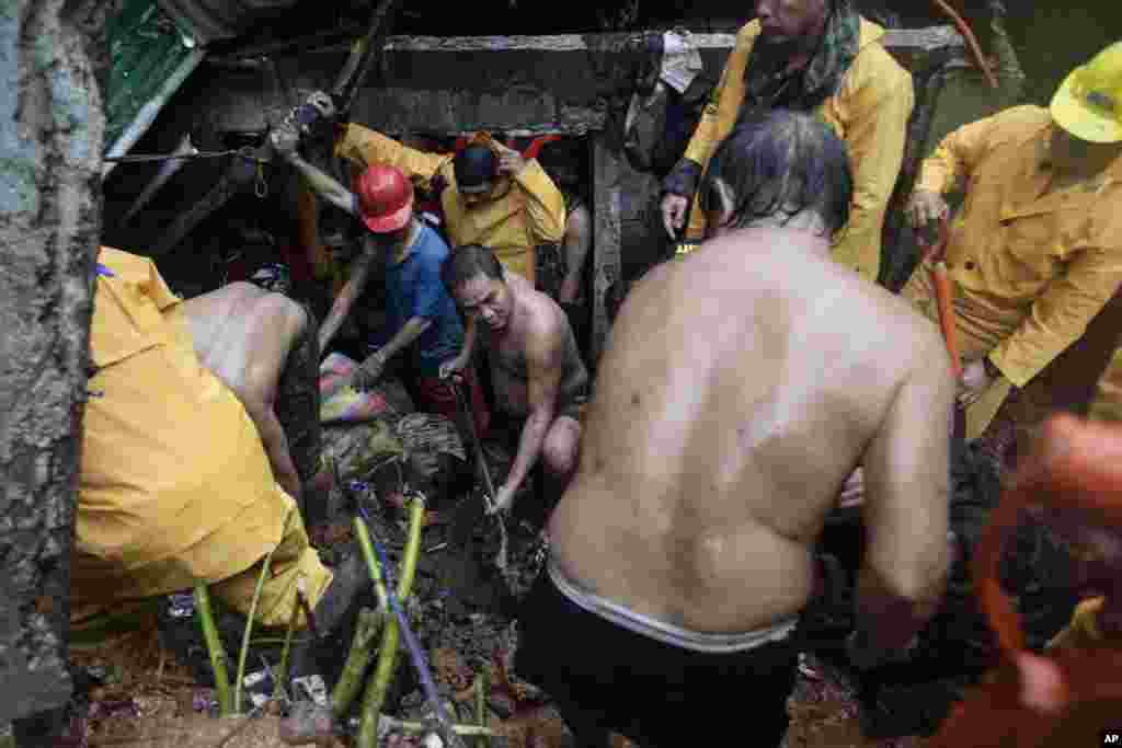 Philippine volunteers dig for survivors where four homes collapsed in a landslide in Quezon City, Philippines, August 7, 2012.